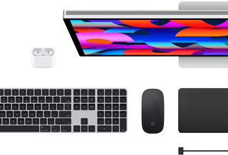 Mặt trên của các phụ kiện Mac: Studio Display, AirPods, Magic Keyboard, Magic Mouse, và Magic Trackpad